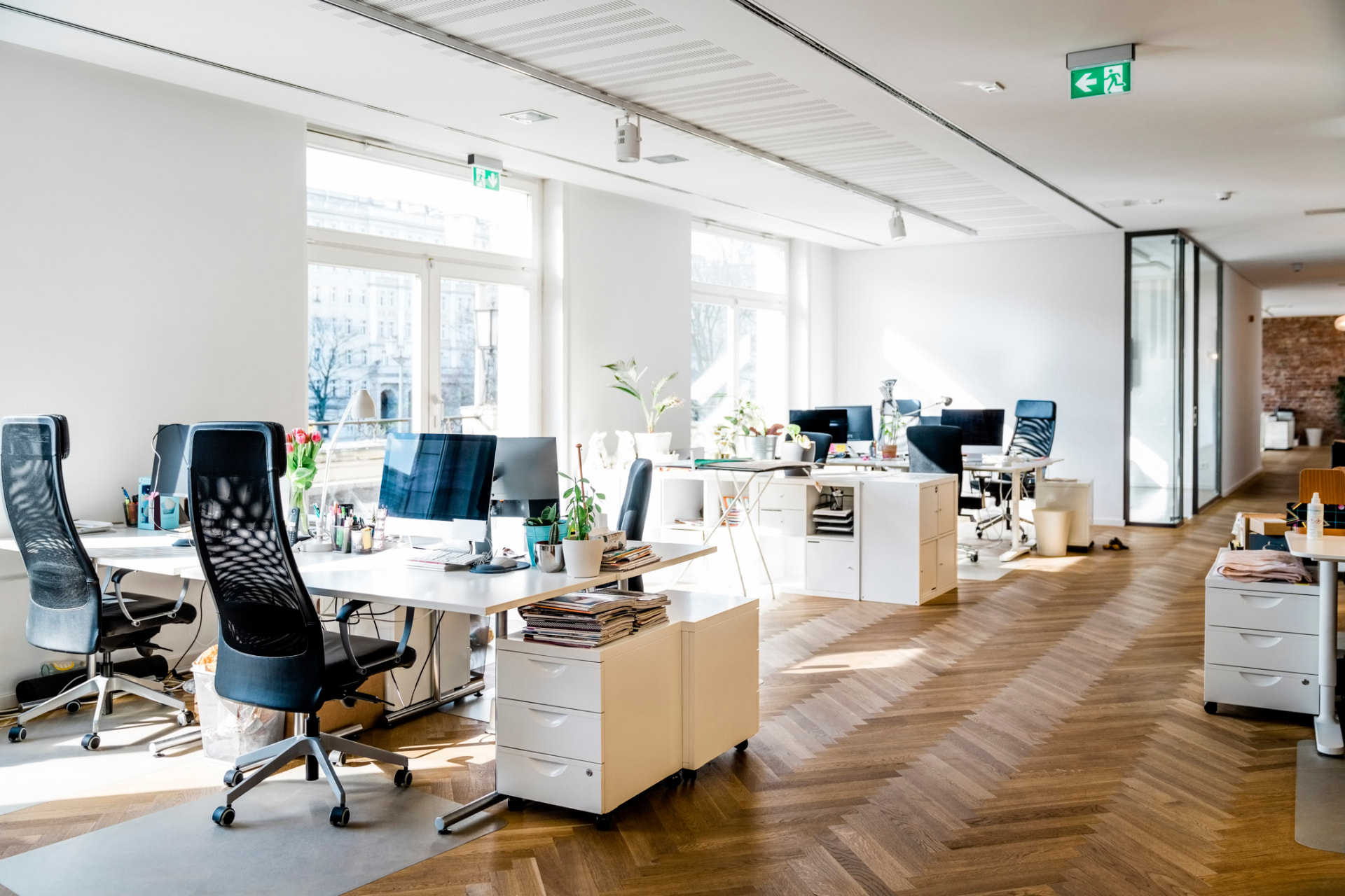Moderner Arbeitsplatz mit Stehschreibtisch, Wandschrank und Trennwand